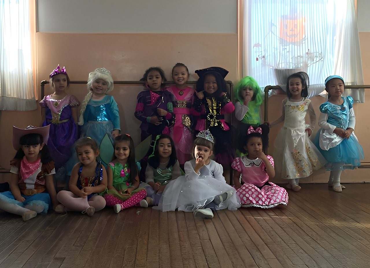 Children dressed in colorful Halloween costumes posing indoors.