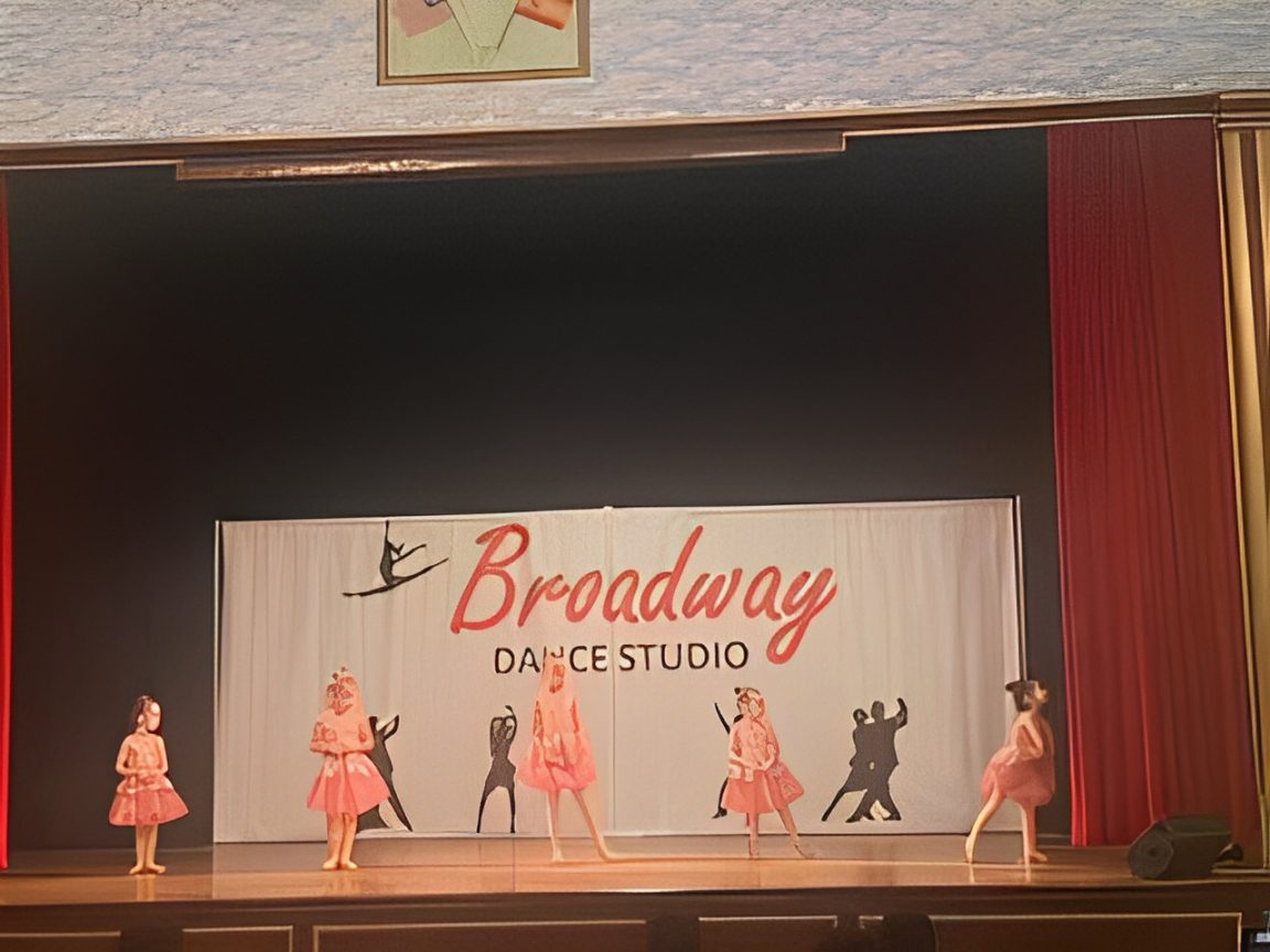 Children performing on stage at dance studio.