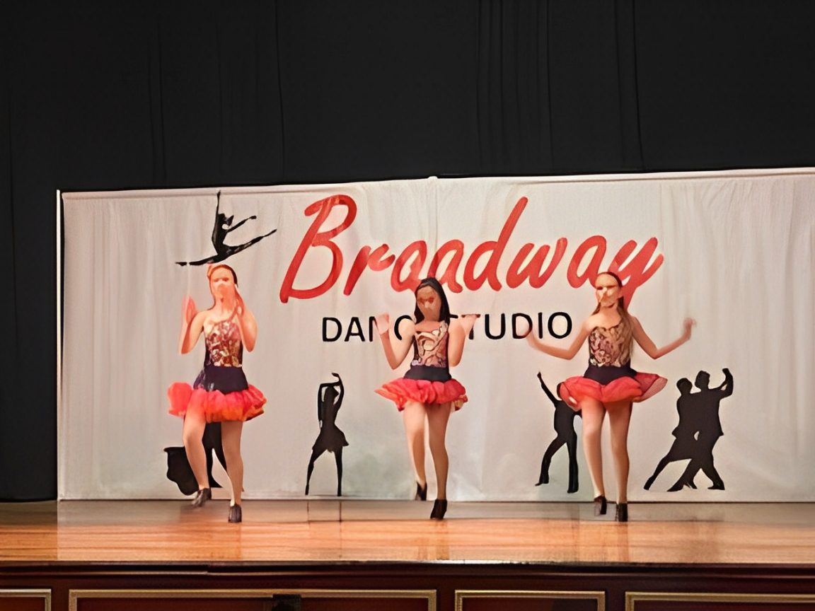 Three dancers performing on stage.